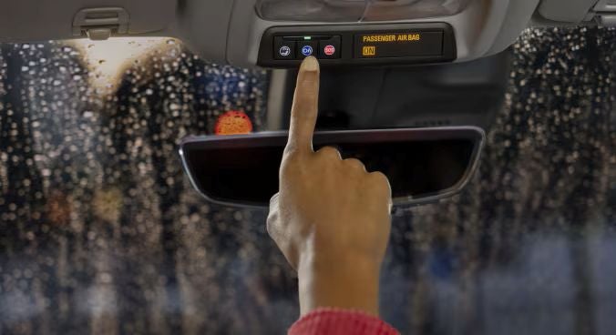 A woman hand pushing the OnStar button