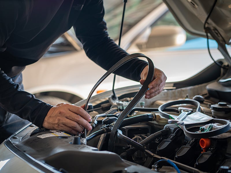 A service expert replacing a car belt in a car